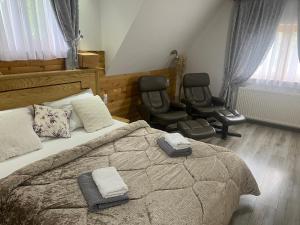 1 Schlafzimmer mit einem großen Bett und 2 Stühlen in der Unterkunft Rustic Inn River in Plitvička Jezera