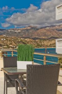 una mesa con sillas y una maceta en el balcón en APARTMENT DOWNTOWN, en Karpathos