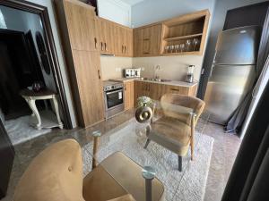 cocina con armarios de madera, mesa y silla en APARTMENT DOWNTOWN, en Karpathos