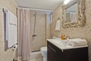 a bathroom with a sink and a toilet and a mirror at APARTMENT DOWNTOWN in Karpathos