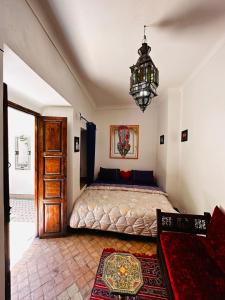 a bedroom with a bed and a chandelier at riad msholidays - privatisé jusqu'à 6 personnes - bassin in Marrakesh