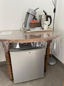 a table with a coffee maker on top of a refrigerator at Chambre d’hôte Chancelier Guerin in Mont-lʼEvêque