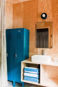 uma casa de banho com um armário azul ao lado de um lavatório em The Dance Hall Cottage on Charleston Lake em Delta