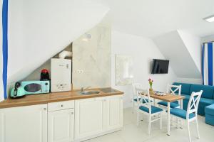 a kitchen and dining room with a table and chairs at 3 Kolory in Rogowo