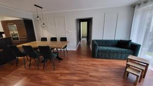 a living room with a table and chairs and a couch at Apartament Jeździecki Leszno in Leszno