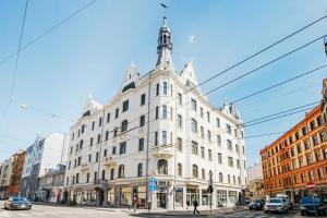 um edifício branco com uma torre em cima em Constantine Apartments em Riga