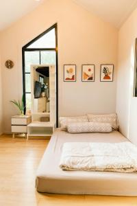 a bedroom with a large bed and a large window at Cana​ Garden​ House​ โฮมสเตย์​ in Ban Khok