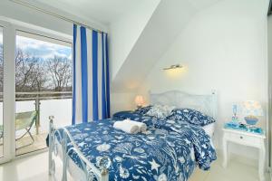 a bedroom with a blue and white bed and a balcony at 3 Kolory ADULTS ONLY in Rogowo