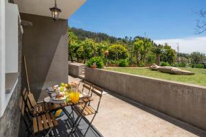 a table and chairs on the balcony of a house at Casinha dos Canhas by An Island Apart in Ponta do Sol