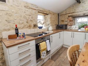 斯溫頓的住宿－5 Packhorse，厨房配有白色橱柜和炉灶烤箱。