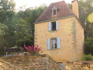 Un viejo edificio de ladrillo con dos ventanas y una sombrilla. en Tour Milou, en Beynac-et-Cazenac 11 fotos más