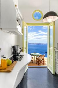 a kitchen with a view of the ocean at Sensyo Traditional Caves in Firostefani
