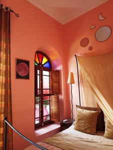 a bedroom with a bed and a window at Dar Taliwint in Marrakesh