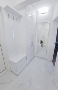 a white bathroom with white walls and a mirror at Nova City Apartments in Varna City