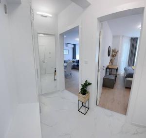 Nova City Apartments في مدينة فارنا: غرفة معيشة بيضاء مع مرآة وأريكة
