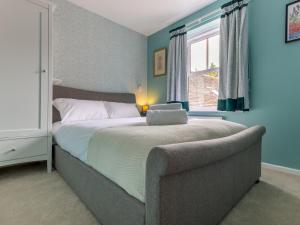 1 dormitorio con 1 cama y 1 sofá junto a una ventana en Pass the Keys The William Morris Lodge in the centre of Ludlow, en Ludlow