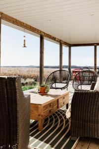eine Veranda mit einem Tisch und Stühlen sowie Aussicht in der Unterkunft Fox Lane - Prince Edward County Farmhouse in Picton