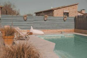 a swimming pool in a backyard with a wooden fence at Casa Diana A in Girona