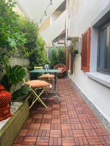 un patio con tavolo e sedie su un pavimento in mattoni di Casa sole a Stresa