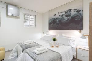 a white bedroom with a large bed with towels on it at Incredible luxury location Banús beach for families in Marbella