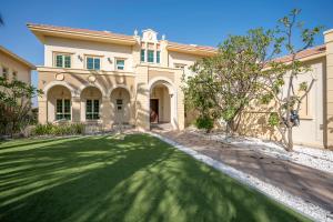 uma casa grande com um relvado verde em frente em Jumeirah Islands Private Pool Villa em Dubai