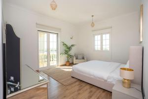 a white bedroom with a bed and a window at Jumeirah Islands Private Pool Villa in Dubai