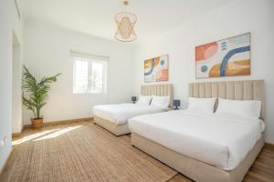 1 dormitorio con 2 camas y una maceta en Jumeirah Islands Private Pool Villa, en Dubái