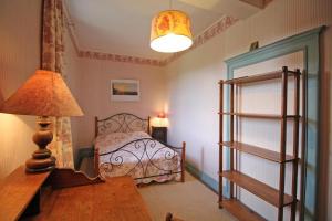 a bedroom with a bed and a lamp and a table at Le jardin in Saint-Priest-Taurion