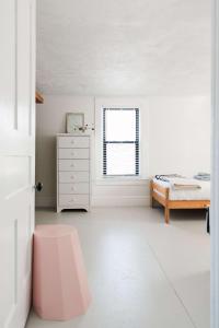 a white bedroom with a bed and a window at Hart House a fresh 3 bedroom century home in Cherry Valley