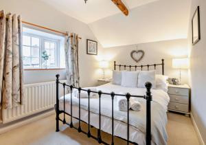 a bedroom with a black bed and a window at Wren Cottage - Bedale in Hornby