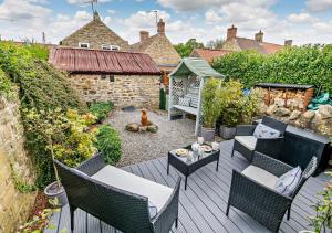 an outdoor patio with chairs and a table at Wren Cottage - Bedale in Hornby