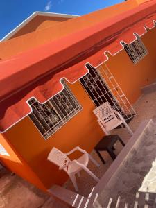 La Cana的住宿－La casita，橙色的建筑,配有两把椅子和一张桌子