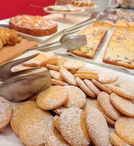 - un bouquet de tartes et de pâtisseries sur une table dans l'établissement Park Hotel Sancelso, à Bellamonte