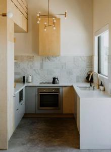 a kitchen with a sink and a stove at Hygge House Cozy Boutique Guest House in Hillier