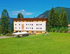 a large building with a green field in front of it at Park Hotel Sancelso in Bellamonte