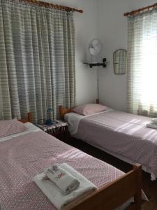 sypialnia z 2 łóżkami i oknem z zasłonami w obiekcie Seaby Apartment w mieście Órmos