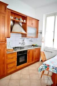 een keuken met houten kasten en een fornuis met oven bij La casetta nella Città dei due Mari in Sestri Levante