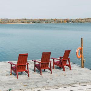 drie stoelen en een tafel op een steiger aan een meer bij Narrows Nook - Prince Edward County Waterfront in Deseronto