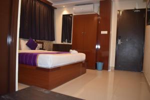 a hotel room with a bed and a mirror at Hotel UR Comforts Jayanagar in Bangalore