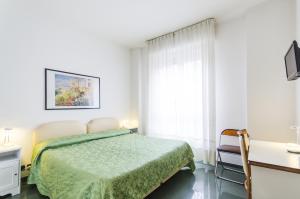 a bedroom with a bed and a desk and a window at Hotel Molise 2 in Milan