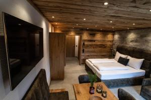 a bedroom with a bed and a couch and a table at Apartment Alpinflair 1 in Kaprun