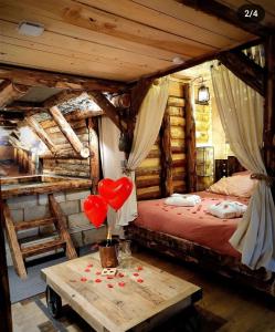 a bedroom with a bed with two red hearts on a table at La mine de Buck in Le Biot