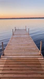 a wooden dock in the middle of a body of water at Tanglewood - Large Waterfront Home in PEC ST-2020-0172 in Waupoos