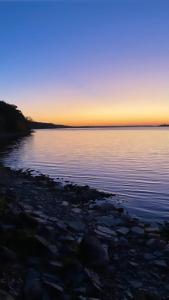 a large body of water with the sun setting at Tanglewood - Large Waterfront Home in PEC ST-2020-0172 in Waupoos +36 photos