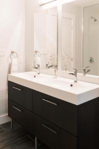 a bathroom with a sink and a large mirror at Tanglewood - Large Waterfront Home in PEC in Waupoos