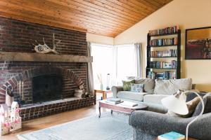 a living room with a brick fireplace at Tanglewood - Large Waterfront Home in PEC in Waupoos