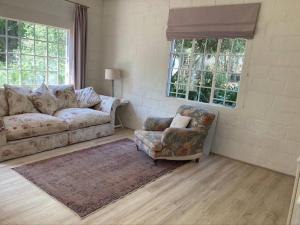a living room with a couch and a chair at Dainty Bess cottage in Middelburg