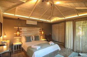 a bedroom with a large bed with two towels on it at Nostos Hotel in Afitos