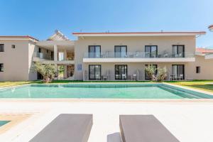 a villa with a swimming pool in front of a house at AlexMare Hotel Fourka in Skala Fourkas