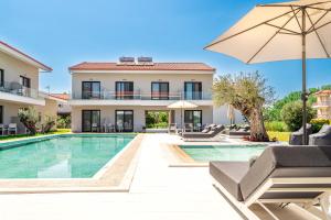 a villa with a swimming pool and an umbrella at AlexMare Hotel Fourka in Skala Fourkas
